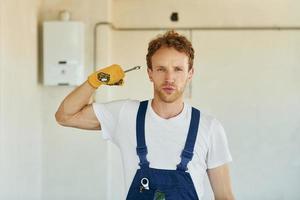 lavoro è fatto. giovane uomo Lavorando nel uniforme a costruzione a giorno foto