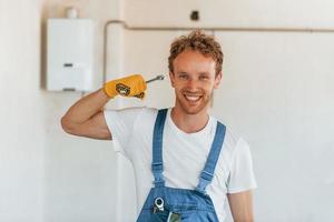 professionale occupazione. giovane uomo Lavorando nel uniforme a costruzione a giorno foto