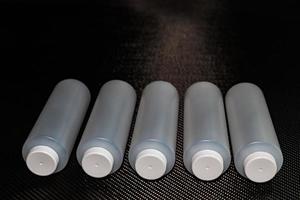 bianca plastica contenitori con palpebre su carbonio fibra foto