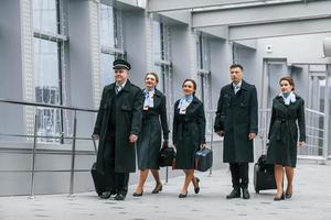 aereo equipaggio nel opera uniforme è insieme all'aperto nel il aeroporto foto