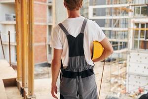 riposo al chiuso. giovane uomo Lavorando nel uniforme a costruzione a giorno foto