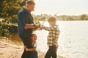 padre con figlio e figlia su pesca insieme all'aperto a estate foto