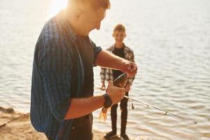 concezione di hobby. padre e figlio su pesca insieme all'aperto a estate foto