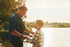 padre e figlio su pesca insieme all'aperto a estate foto