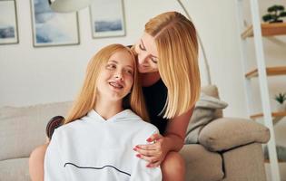 positivo emozioni. femmina adolescente con sua madre è a casa a giorno foto