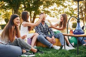 potabile gioco. gruppo di giovane persone avere un' festa nel il parco a estate giorno foto