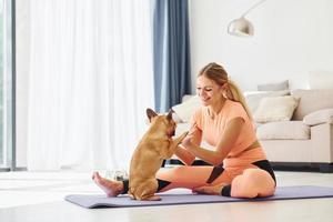 su fitness stuoia. donna con carlino cane è a casa a giorno foto