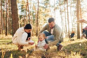 estate felicità. famiglia di padre, madre e poco figlia è nel il foresta foto