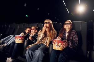 facciale espressioni. gruppo di bambini seduta nel cinema e Guardando film insieme foto