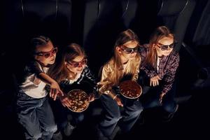 amici Guardando film insieme. gruppo di bambini seduta nel cinema foto