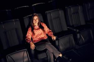 adulto donna seduta nel il cinema e Guardando film foto