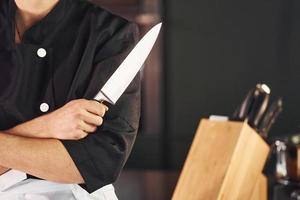 professionale giovane capocuoco cucinare nel uniforme in piedi e preparazione per il opera su cucina foto