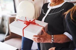 anziano donna con famiglia e amici festeggiare un' compleanno in casa foto