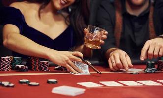 vicino su Visualizza di elegante giovane persone mani quello giocando poker nel casinò foto