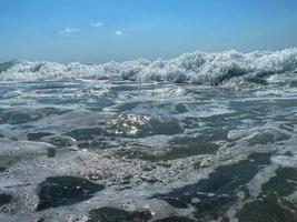 onde, spruzzi di acqua su il spiaggia a il mare su vacanza nel un' turista caldo orientale tropicale nazione meridionale Paradiso ricorrere su vacanza. il sfondo foto