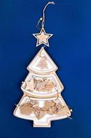 Natale Immagine con piatto nel forma di natale abete albero con di legno natale giocattoli e stella su superiore su blu. foto