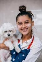 sorridente donna nel cucina Tenere carino bianca maltese cane foto