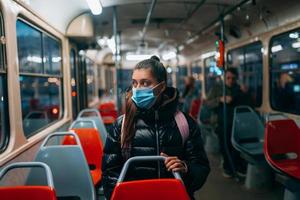 giovane donna con maschera in viaggio nel il pubblico trasporto. foto