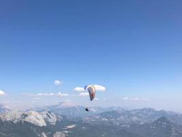 persona parapendio al di sopra di montagne contro cielo foto