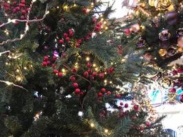 verde rami di un' soffice Natale festivo nuovo anno albero con giocattoli e luminosa raggiante leggero bulbi e ghirlande, sfondo foto
