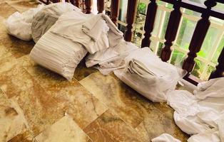 Hotel camera pulizia. il lavoratore raccoglie sporco biancheria e asciugamani nel borse e mette loro nel il atrio. Manutenzione di pulizia per turisti, servizio per vacanzieri foto