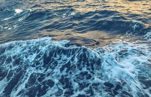 blu acqua con bianca schiuma. bellezza di mare viaggio. riposo di il acqua nel un' caldo nazione. sfondo, struttura. naturale naturale sfondo foto