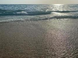 onde, spruzzi di acqua su il spiaggia a il mare su vacanza nel un' turista caldo orientale tropicale nazione meridionale Paradiso ricorrere su vacanza. il sfondo foto