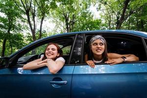 Due amiche scemo in giro e ridendo insieme nel un' auto foto