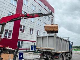 caricare spazzatura a partire dal il serbatoio nel un' specializzato auto spazzatura camion. un' specializzato auto rimuove spazzatura foto