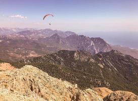 montagne contro il blu cielo. erba e cespugli crescere su il montagna. tempo libero. parapendio mosche nel il cielo. aria viaggio nel un' caldo aria Palloncino foto