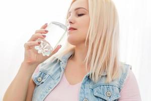 salutare giovane donna con bicchiere di fresco acqua foto