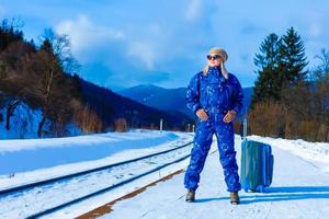 giovane donna nel inverno Abiti in attesa per sua treno foto