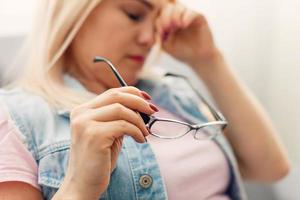 affaticato donna d'affari assunzione via bicchieri stanco di computer opera, oberati di lavoro donna si sente occhio sforzo tensione problema foto