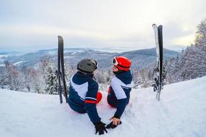 sciatore rilassante a soleggiato giorno su inverno stagione con blu cielo nel sfondo foto