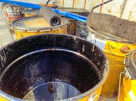 costruzione luogo. su il terra siamo botti di dipingere e resina. nero resina è rovesciato a partire dal il botte. su il botti bugie un' blu pesante fascio e un' rullo, esso ha nero dipingere su esso foto