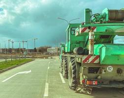 boom genere gru, camion gru a il costruzione luogo di un' nuovo microdistretto, pesante veicoli segnato con un' pesante camion cartello. mezzi di trasporto di edificio materiale foto