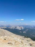 atleta insieme con un' turista mosche su un' parapendio contro il sfondo di un' nuvoloso cielo al di sopra di il montagne nel estate su un' soleggiato giorno foto