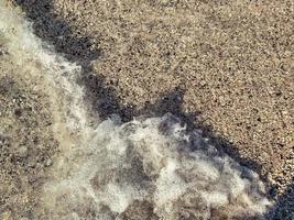 mare onda, schiuma vicino il costa. mare costa, sabbioso spiaggia con sale acqua. distesa di il mare, ribollendo schiuma di acqua foto