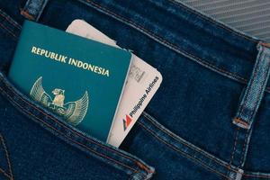 Indonesia nel luglio 2022. un indonesiano passaporto e un' Filippine le compagnie aeree imbarco passaggio nel un' jeans tasca. foto