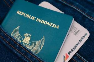 Indonesia nel luglio 2022. un indonesiano passaporto e un' Filippine le compagnie aeree imbarco passaggio nel un' jeans tasca. foto