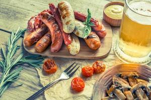 salsicce alla griglia con un bicchiere di birra foto