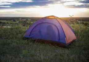 turista tenda su montagna paesaggio a tramonto nel estate. turismo avventura viaggio stile di vita concetto. foto