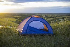 turista tenda su montagna paesaggio a tramonto nel estate. turismo avventura viaggio stile di vita concetto. foto