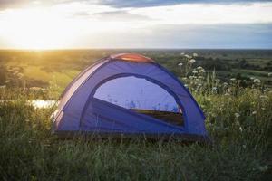 turista tenda su montagna paesaggio a tramonto nel estate. turismo avventura viaggio stile di vita concetto. foto