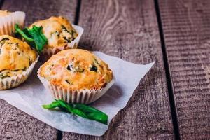 muffin con spinaci e formaggio su di legno tavolo sfondo. salutare prima colazione cibo concetto. foto