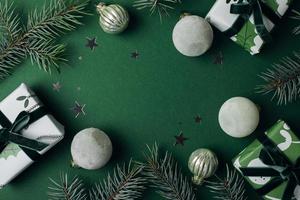 piatto posare composizione con abete albero, regalo scatole e Natale arredamento su verde sfondo. allegro Natale saluto carta, telaio. inverno natale vacanza tema. contento nuovo anno. piatto posizione. foto