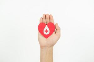 mani Tenere cuore per dando vita carta tagliare su bianca sfondo, sangue trasfusione, mondo sangue donatore giorno. sangue donazione concetto foto