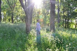 un' giovane tipo nel un' grigio gli sport completo da uomo sta di fronte il sole tra foto