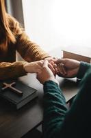 Due persone lettura e studia Bibbia nel casa e pregare insieme.studiando il parola di Dio con gli amici. foto