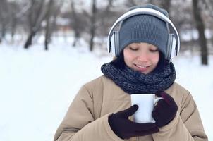 giovane ragazza con cuffie e caffè tazza foto